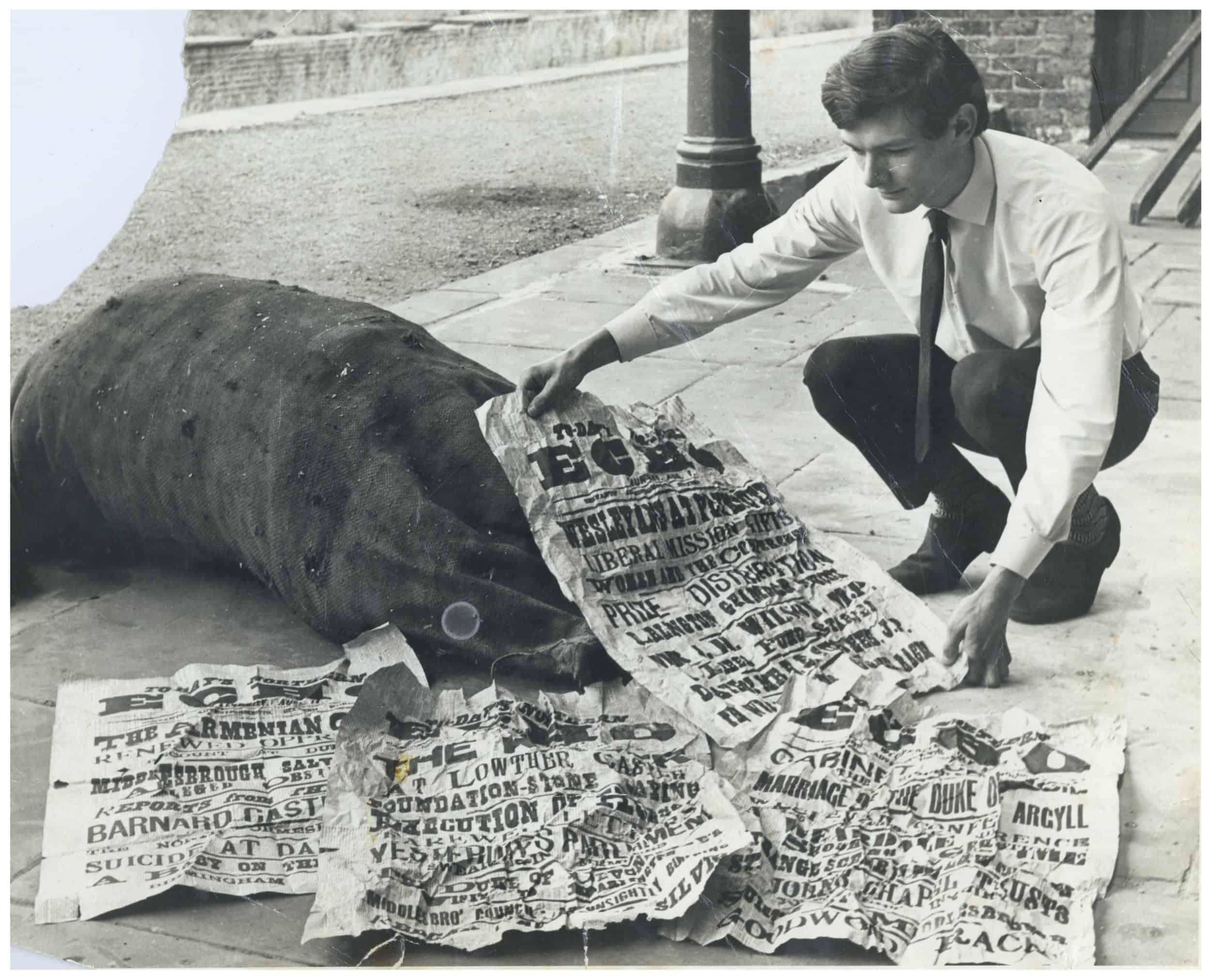 Author looking at Victorian newspapers (1896) found in roof space above ticket office at Boosbeck Railway Station circa 1965